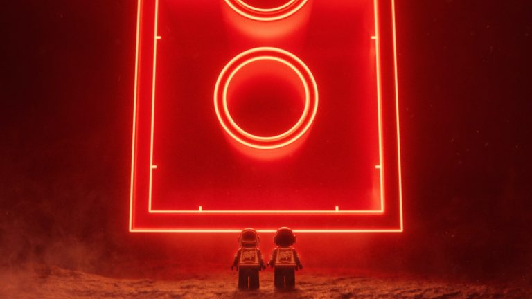 Daft Punk LEGO minifigures standing in front of a glowing red LEGO brick