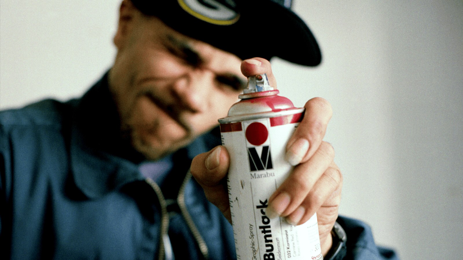 Goldie holding a can of spray paint